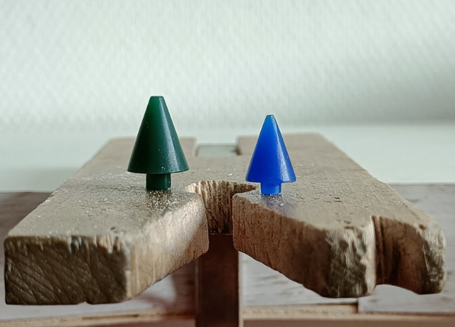 Benchpeg with a green wax and blue wax Christmas tree on top