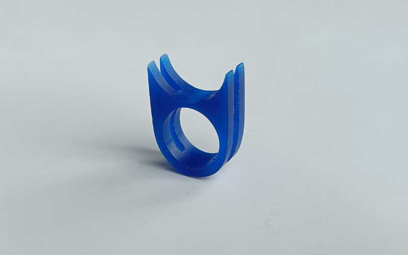 Blue wax ring where the top resembles a half pipe with cut outs over the side of the ring