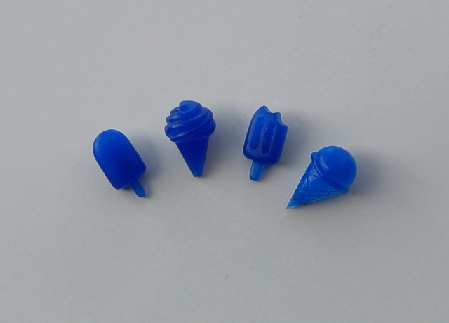 4 blue wax ice crem charms. From left to right popsicle, soft serve, popsicle with a bite taken out, one scoop ice cream
