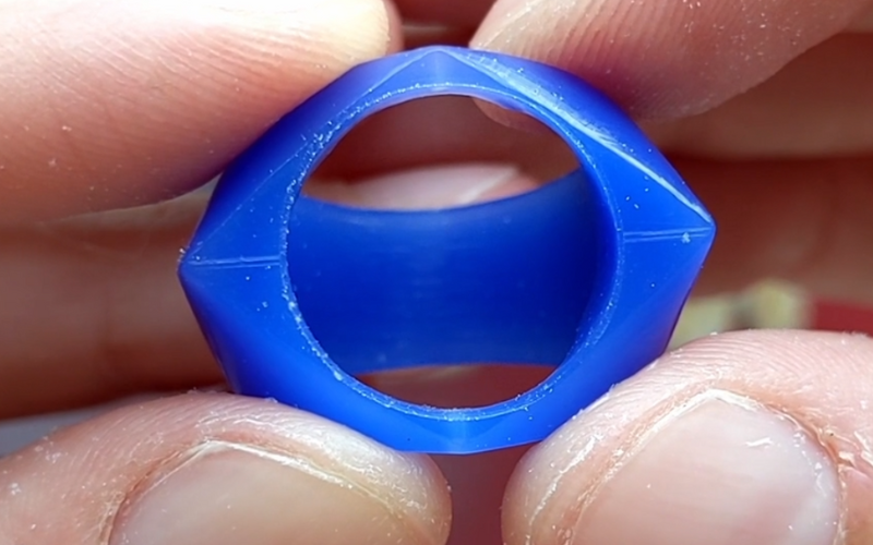 Close up of blue wax ring shaped like a diamond, a large circular hole is made on the top surface of the ring