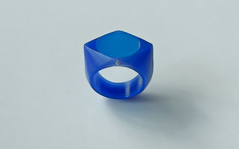 a diamond shaped signet ring from blue wax with a circular center section from turquoise. You can see a hint of the metal that holds the 2 together on the side of the ring 