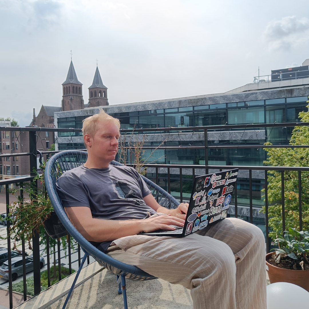 Jussi sitting on the balcony with a laptop in his lap