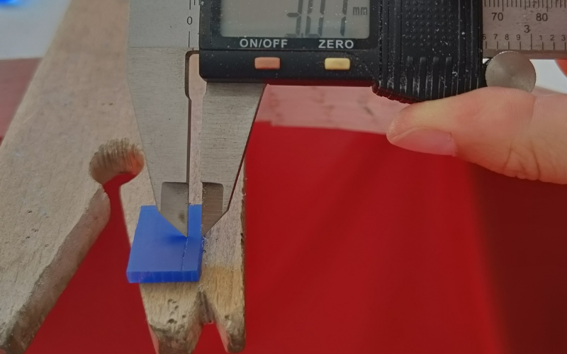 Close up of a piece of wax on a bench peg. The calipers are marking a straight line on the surface of the wax.