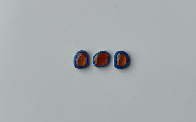 3 rings from blue wax partially stacked on top of each other with melted looking surfaces