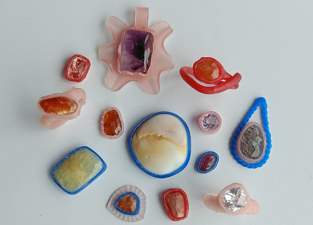 Variety of bezel pieces made from pink sheet wax, blue wire wax, and red mold a wax. All kinds of different stone colors and shapes included