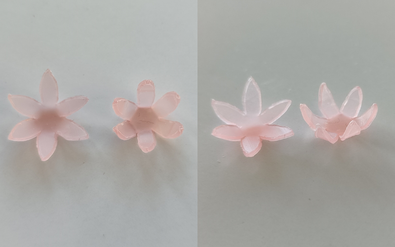 2 side by side photos of the same pieces from different angles. Left 2 flowers from pink sheet wax with folded up petals, left one is folded up gently and right one more acute, photo from above. Right side same but photographed from the side so you can see the amount that the petals go up better. 