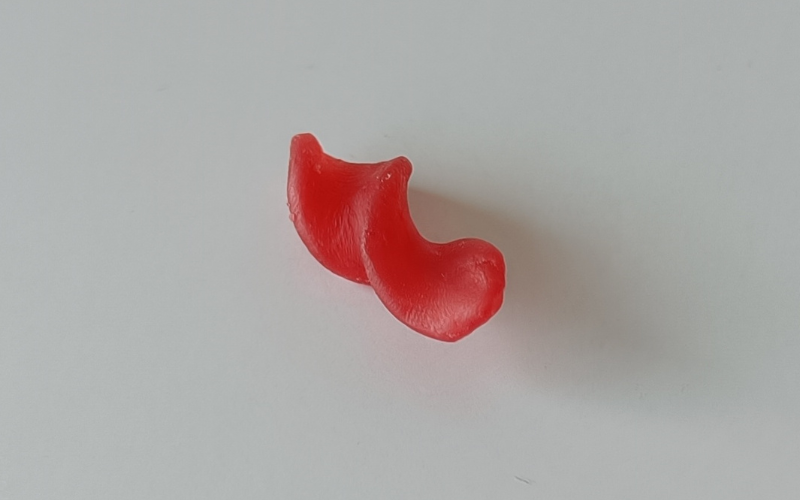 Small piece of red wax formed into a fusilli pasta shape